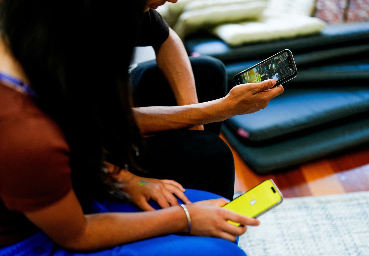 FILE PHOTO: School students pose with their mobile showing social media applications in Melbourne Μαθητές social media
