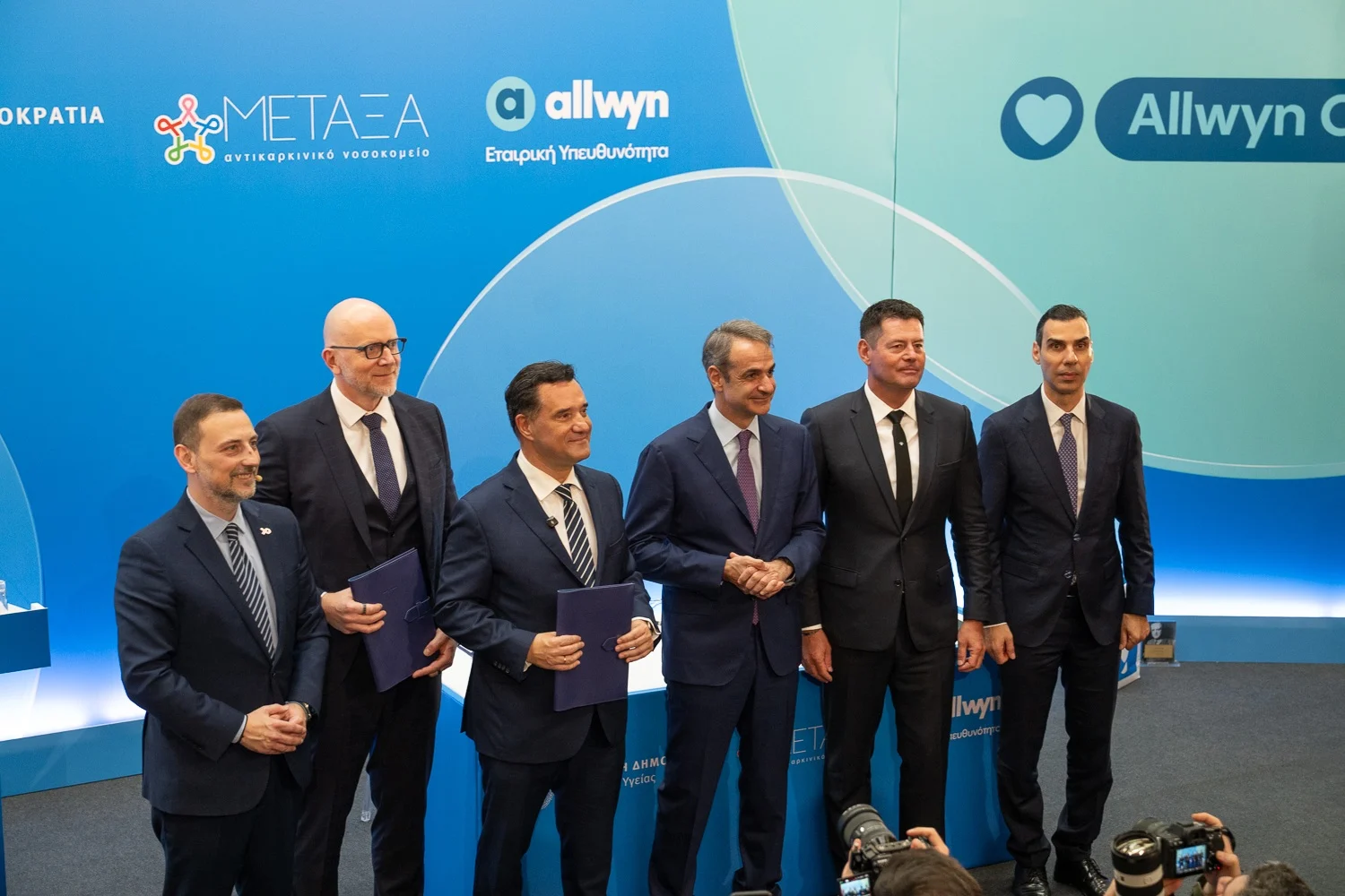Σαράντος Ευσταθόπουλος, Διοικητής του Αντικαρκινικού Νοσοκομείου «Μεταξά», Jan Karas, Πρόεδρος και Διευθύνων Σύμβουλος της Allwyn στην Ελλάδα, Άδωνις Γεωργιάδης, Υπουργός Υγείας, Κυριάκος Μητσοτάκης, Πρωθυπουργός, Karel Komarek, Ιδρυτής και Πρόεδρος της Allwyn, και Μάριος Θεμιστοκλέους, Υφυπουργός Υγείας